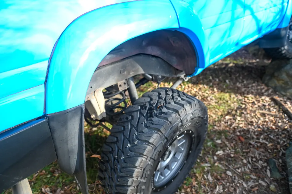 Rear tire compressed up into the wheel arch