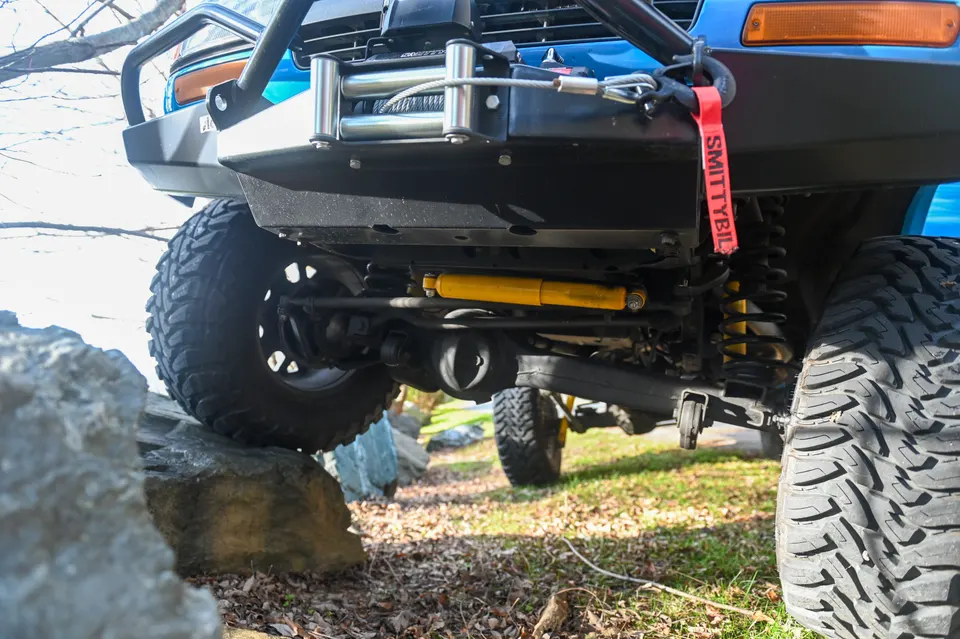 Front axle and skid plate area from below with tire on rock