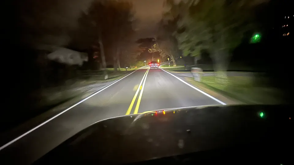 Night driving view showing LED headlight beam on the road